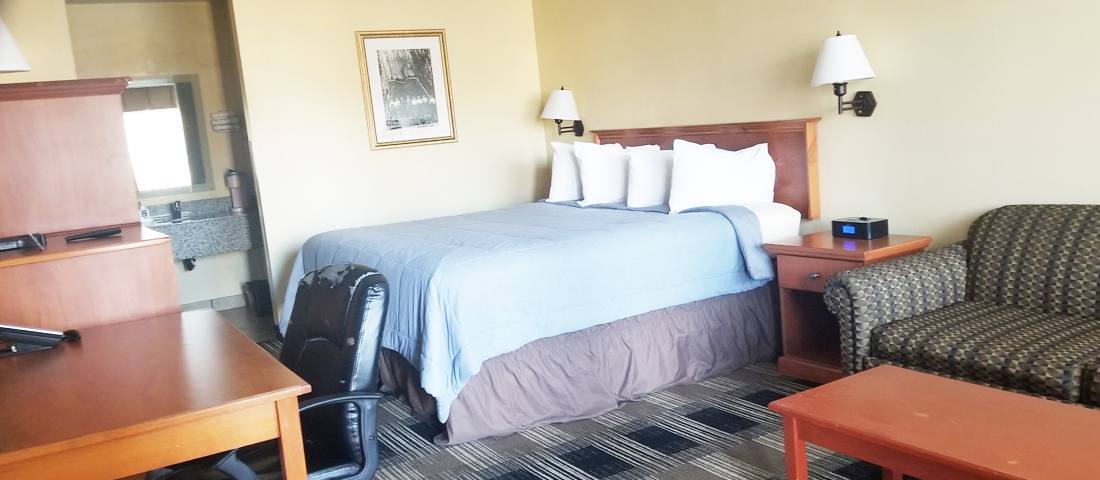 King guest room with a work desk and seating area